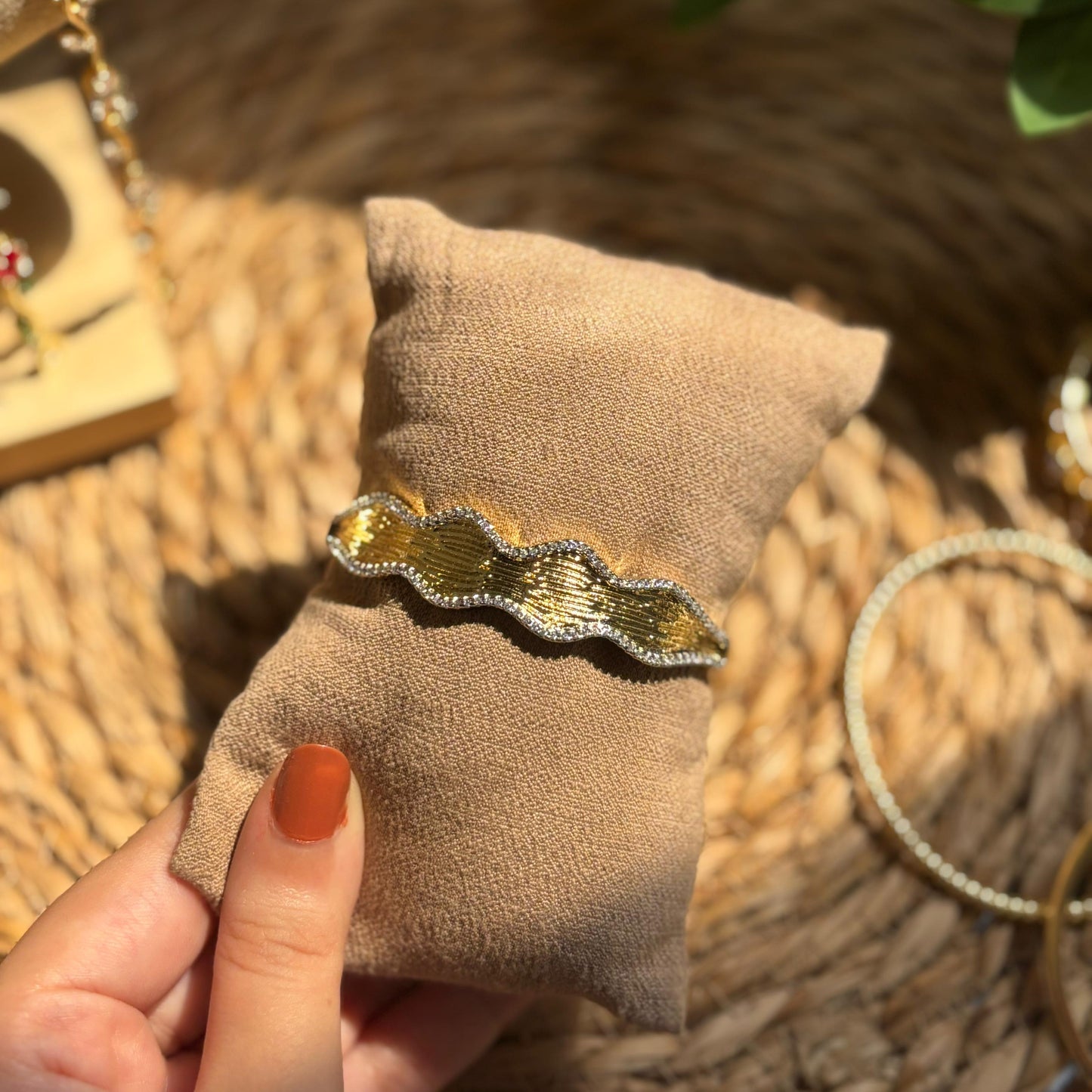 Gold and silver brooch on a beige fabric with a blurred background